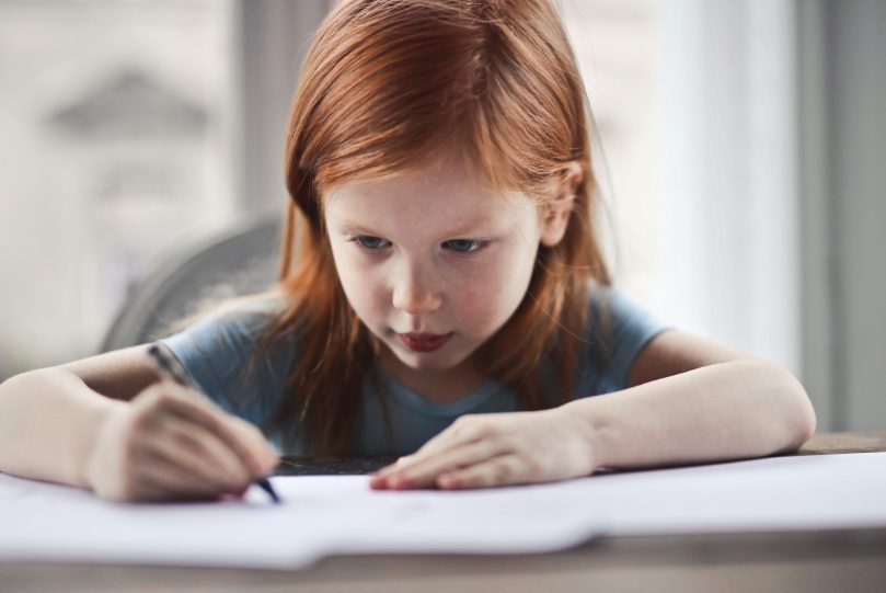 Young girl writing on paper