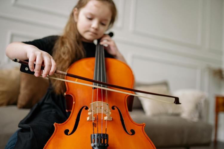 Close-Up Shot of a Girl in Black Dress Playing Cello